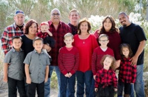 Family posing all wearing matching red plaid